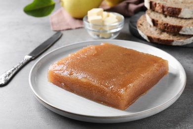 Delicious quince paste on grey table, closeup