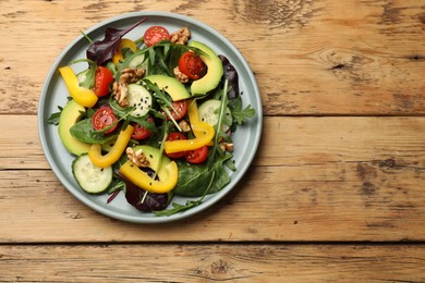 Balanced diet and vegetarian foods. Plate with different delicious products on wooden table, top view. Space for text