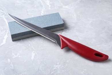 Photo of Boning knife and sharpening stone on grey background
