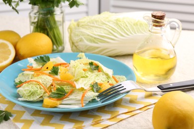 Photo of Tasty salad with Chinese cabbage, products and fork on table