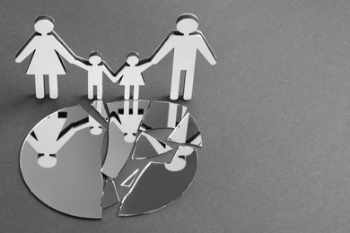 Human figures near broken mirror on gray background, space for text. Divorce concept