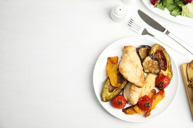 Tasty cooked chicken fillet and vegetables served on white wooden table, flat lay with space for text. Healthy meals from air fryer