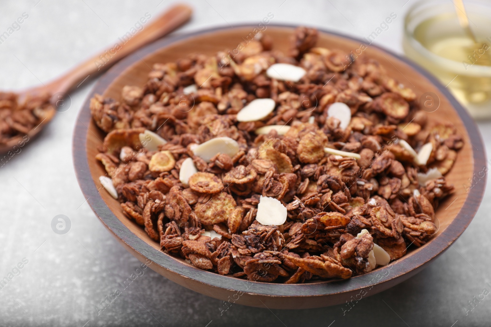 Photo of Tasty granola served with nuts and dry fruits on light grey table, closeup