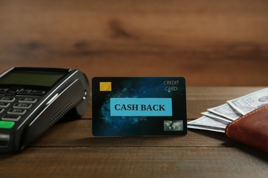 Photo of Credit card with sign Cash Back, wallet and payment terminal on wooden table
