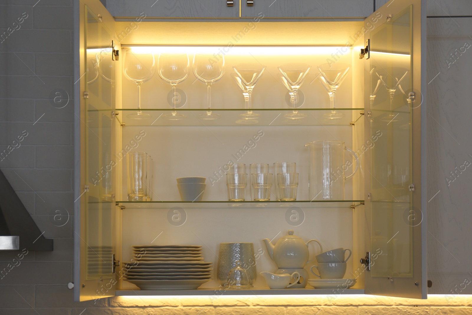 Photo of Cabinet with crockery and glassware. Order in kitchen