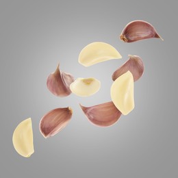 Image of Fresh garlic cloves falling on grey background