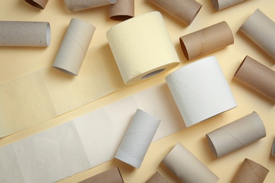 Photo of Full and empty toilet paper rolls on color background, top view