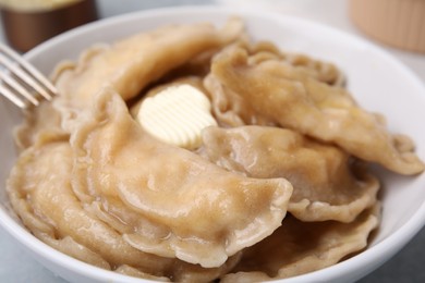 Bowl of delicious dumplings (varenyky) with cottage cheese and butter, closeup