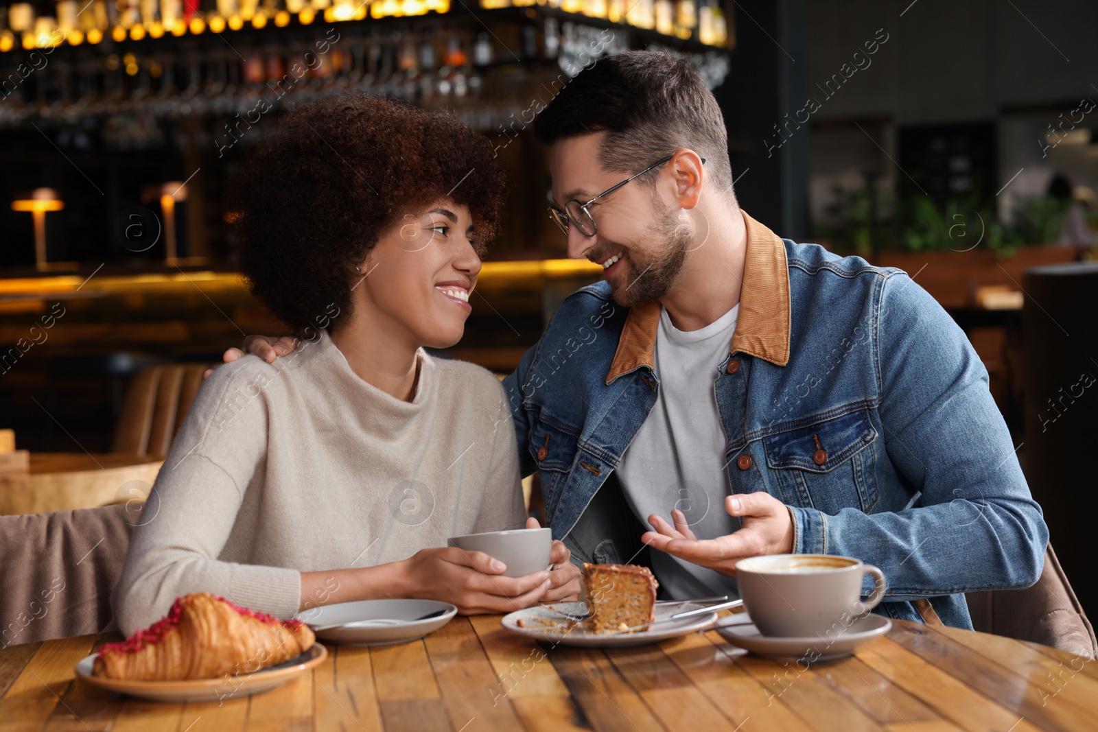 Photo of International relationships. Lovely couple having romantic date in cafe