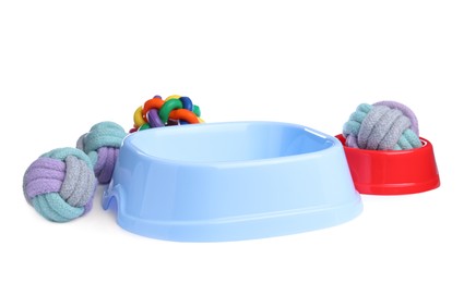 Photo of Feeding bowls and toys for pet on white background