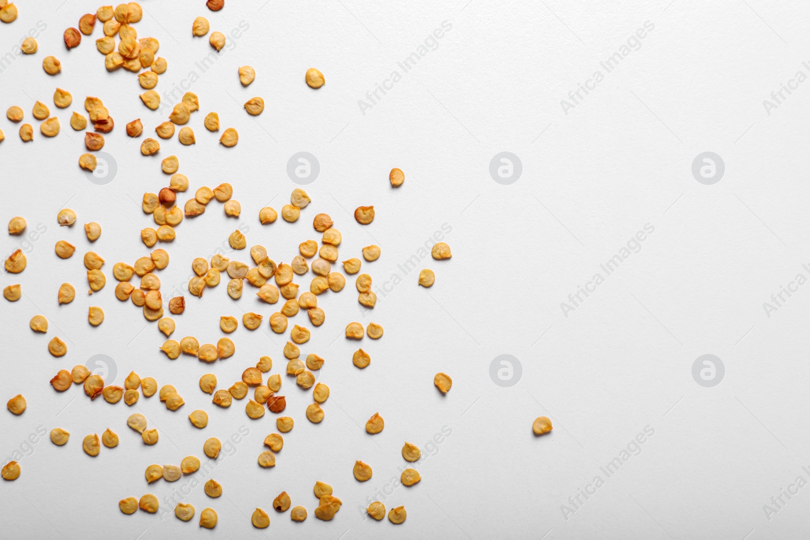 Photo of Many pepper seeds on white background, top view