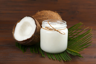 Photo of Composition with organic coconut oil on wooden table. Healthy cooking