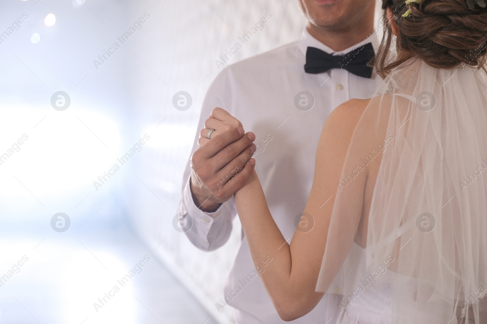 Photo of Happy newlywed couple dancing together in festive hall, closeup