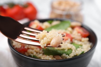 Fork with delicious quinoa salad, closeup view