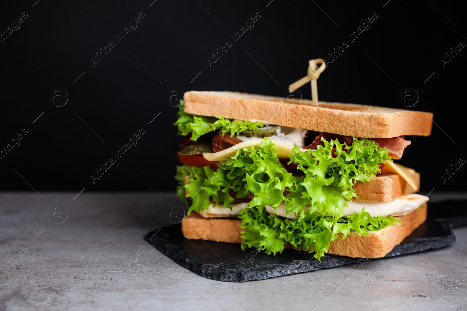 Photo of Yummy sandwich with bacon and chicken on table