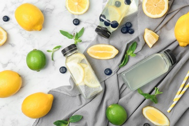 Photo of Flat lay composition with delicious natural lemonade on marble background