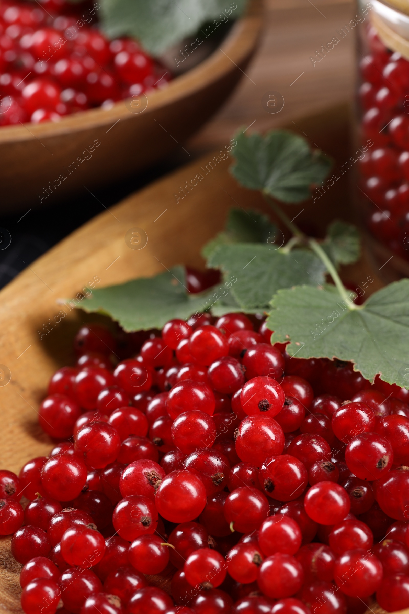 Photo of Ripe red currants and leaves on table, closeup