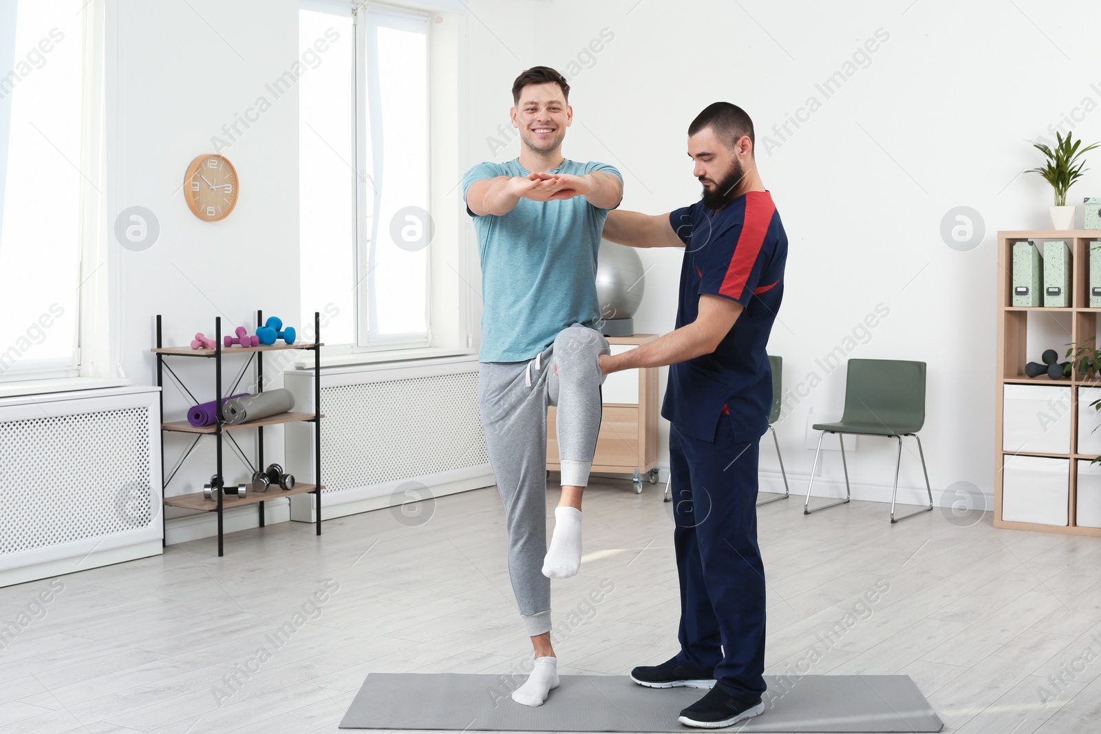 Photo of Physiotherapist working with patient in clinic. Rehabilitation therapy