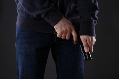 Photo of Man reloading gun on black background, closeup