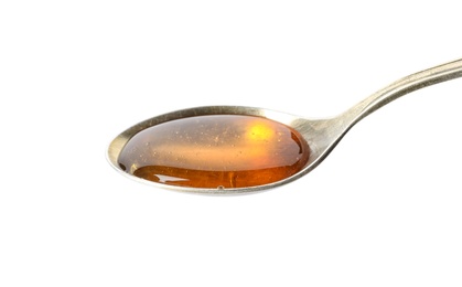 Spoon with delicious honey on white background