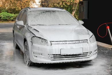 Photo of Auto with cleaning foam at outdoor car wash