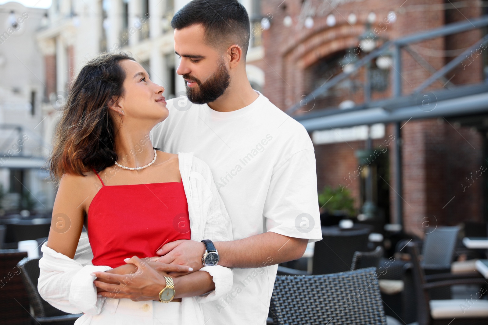 Photo of Happy young couple hugging on city street