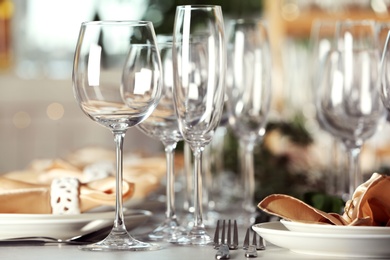 Photo of Table setting with empty glasses, plates and cutlery indoors