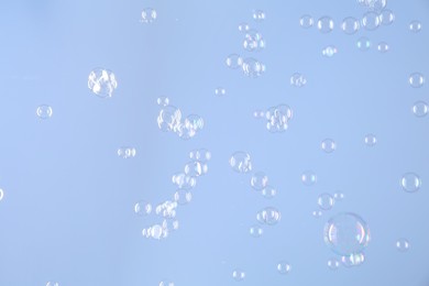 Beautiful transparent soap bubbles on light grey background