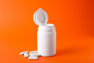 Photo of Jar with chewing gums on orange background