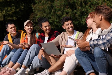 Photo of Group of happy young students learning together in park