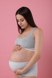 Photo of Beautiful pregnant woman in comfortable maternity underwear on pink background