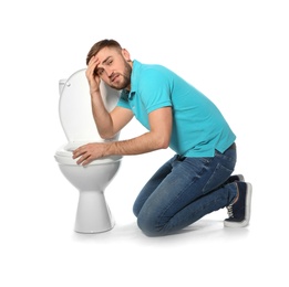 Young man suffering from nausea near toilet bowl isolated on white