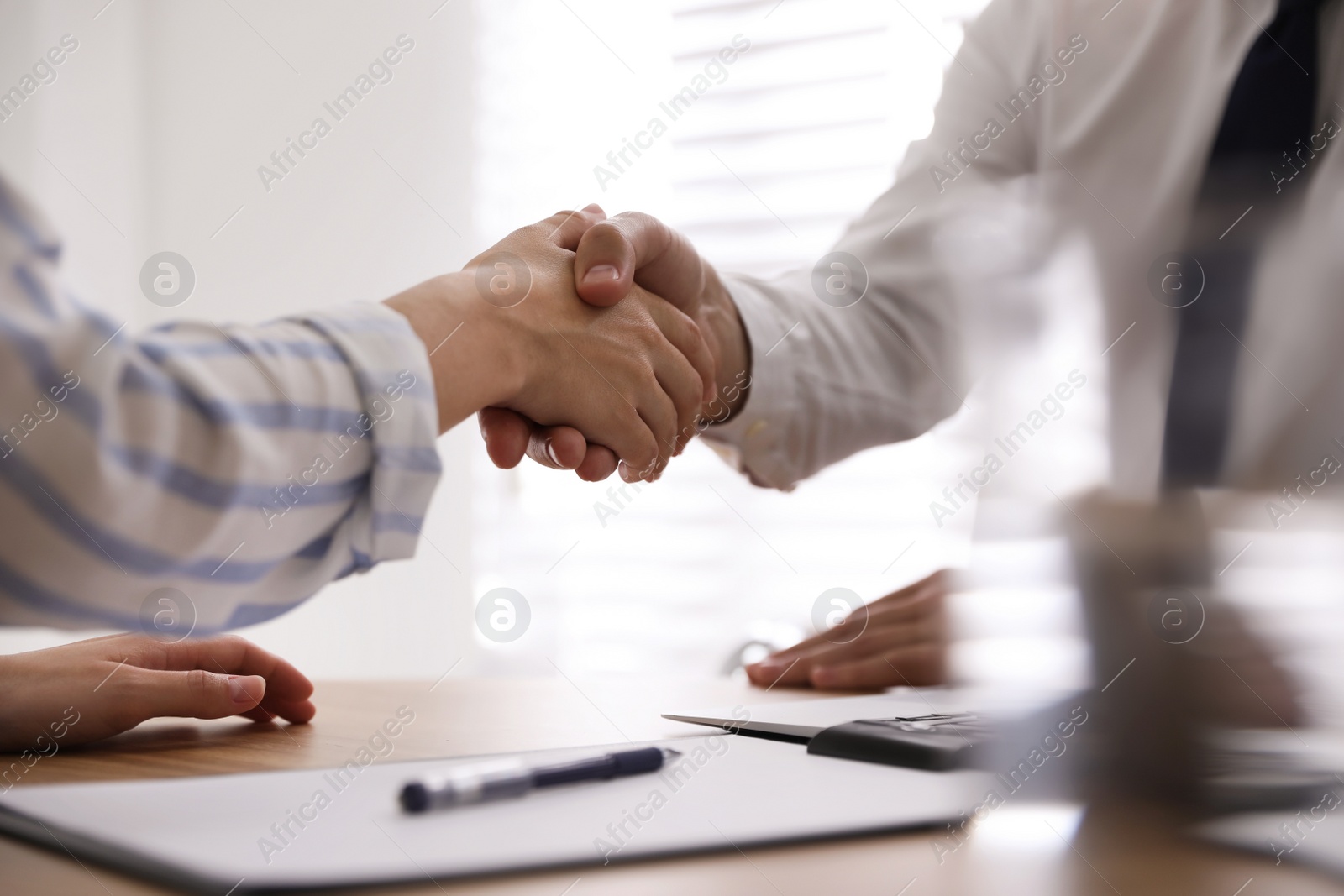 Photo of Business people shaking hands in office, closeup