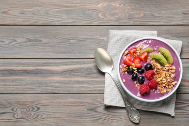 Photo of Delicious acai smoothie with fruits served on grey wooden table, top view. Space for text