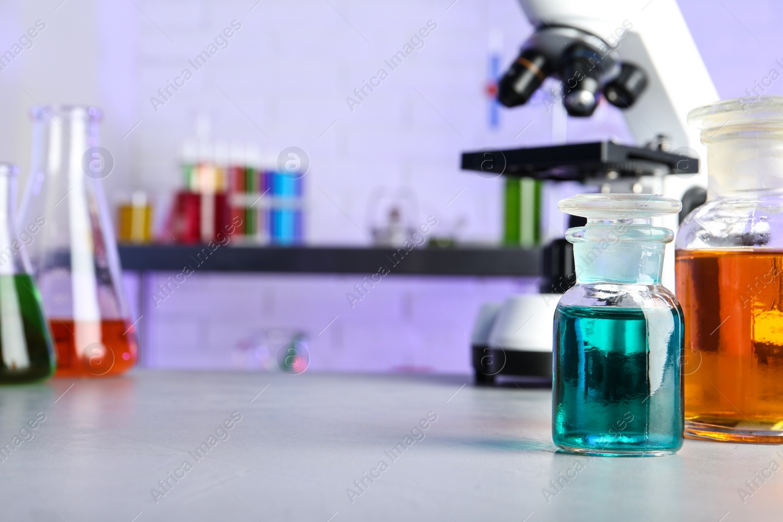 Photo of Different glassware with samples on table in chemistry laboratory. Space for text