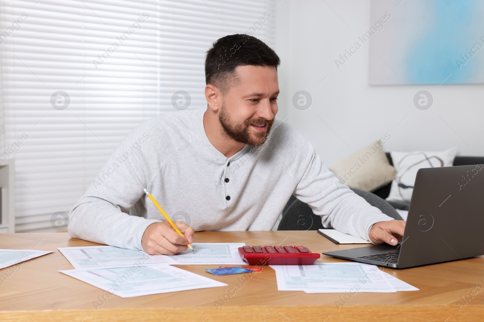 Photo of Man doing taxes at table in room