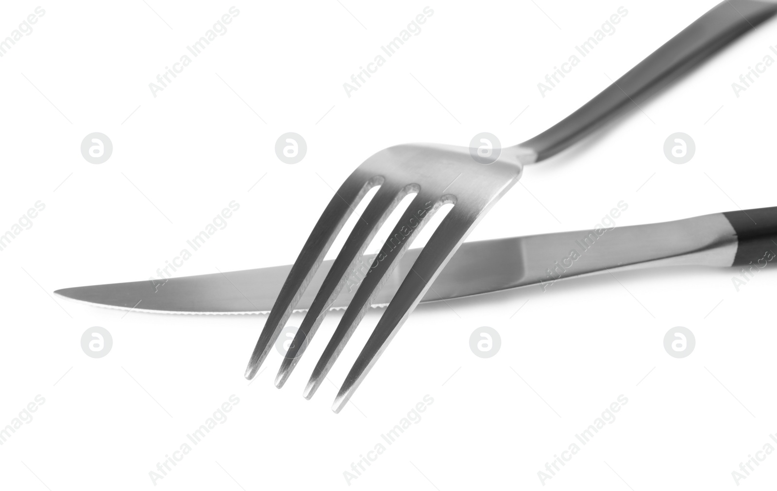 Photo of New fork and knife on white background, closeup