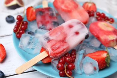 Photo of Tasty refreshing fruit and berry ice pops on plate, closeup