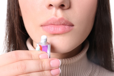 Photo of Young woman applying cold sore cream on lips, closeup