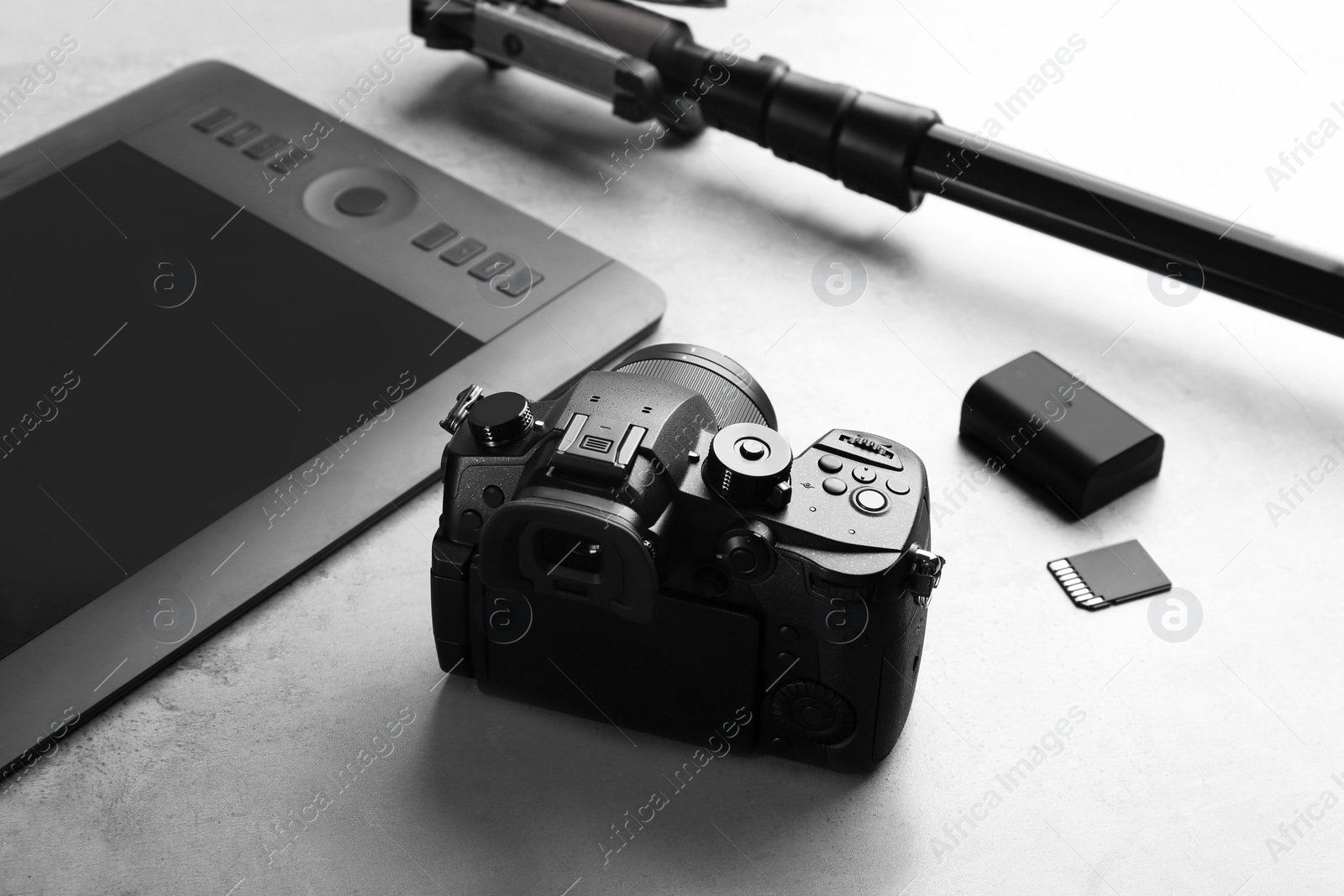 Photo of Modern camera on light grey stone table. Video production industry