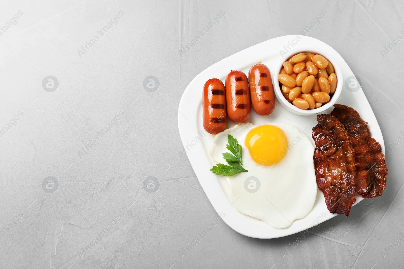 Photo of Delicious breakfast with fried egg served on table, top view. Space for text