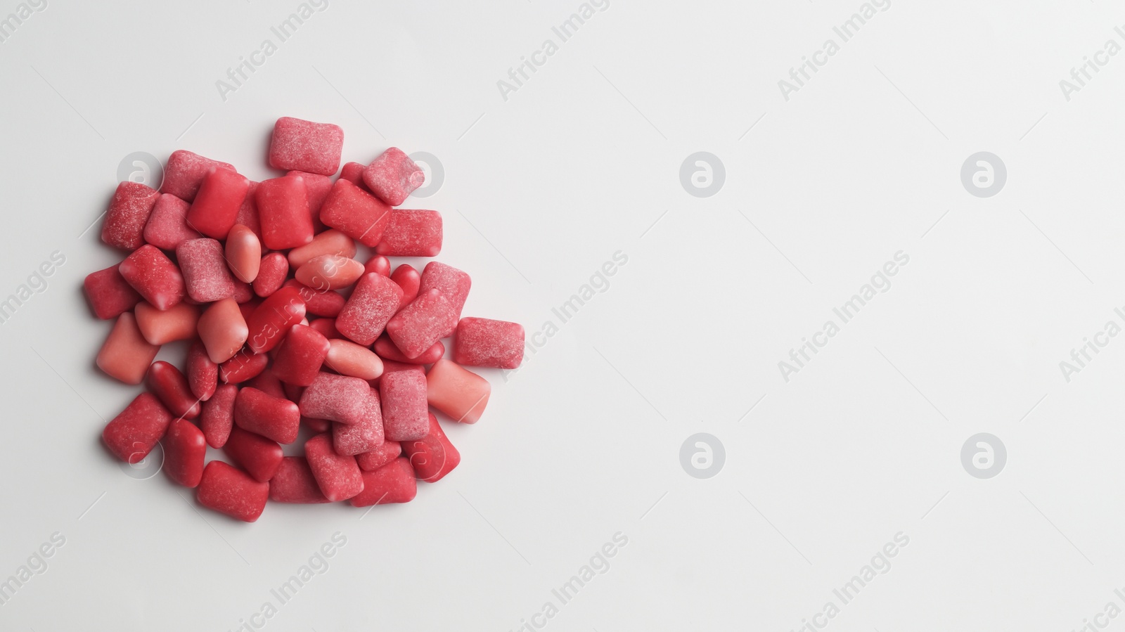 Photo of Sweet chewing gums on white background, top view. Space for text