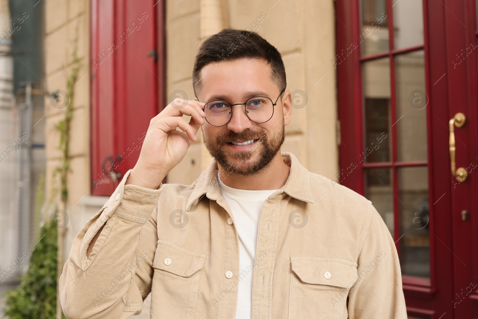 Photo of Portrait of handsome bearded man in glasses outdoors