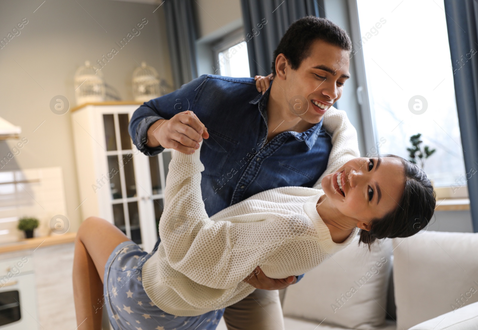 Photo of Lovely young interracial couple dancing at home