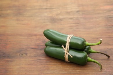Photo of Fresh ripe green jalapeno peppers on wooden table