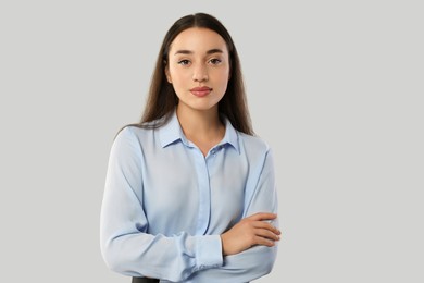 Portrait of beautiful young woman on light grey background