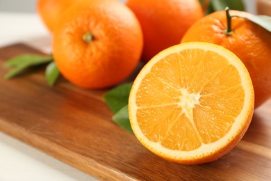 Photo of Delicious ripe oranges on wooden board, closeup