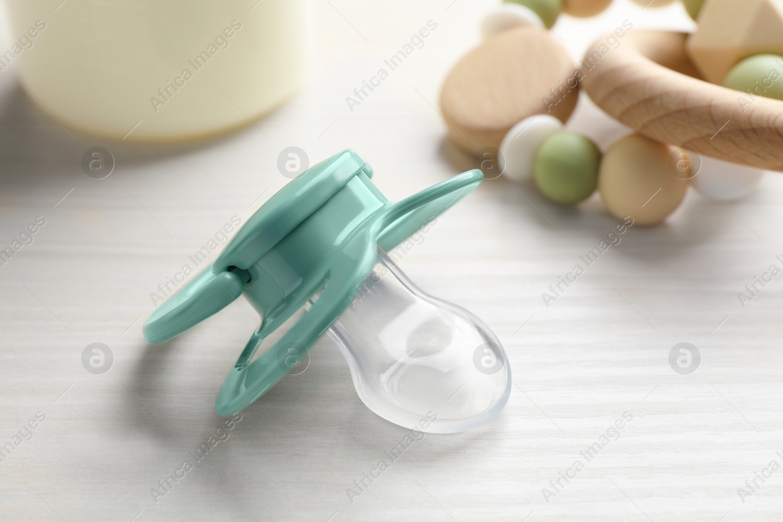 Photo of Baby pacifier on white wooden table, closeup