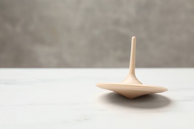 One spinning top on white table, closeup. Space for text