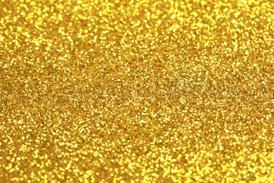 Beautiful golden shiny glitter as background, closeup